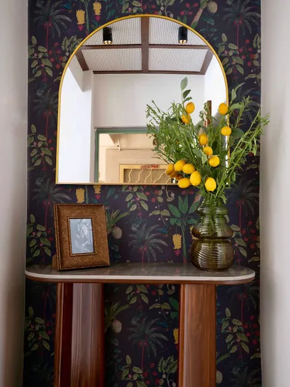 Another view of the 'Modern Muse' foyer, where the dark floral wallpaper and custom console table create an elegant and inviting entryway.