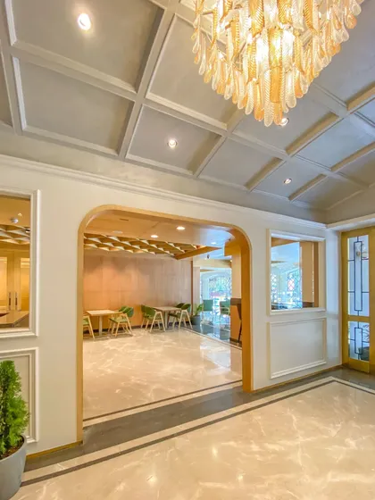 An arched entryway in the Bhopal hotel lobby creates a soft, elegant transition between spaces. The design uses classic architectural forms and a grand chandelier to add a touch of timeless sophistication.