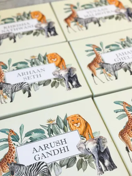 Personalization is key for party favors. Here you can see the custom-printed lids for a safari-themed birthday party, with each child's name elegantly displayed amidst the jungle animal illustrations.
