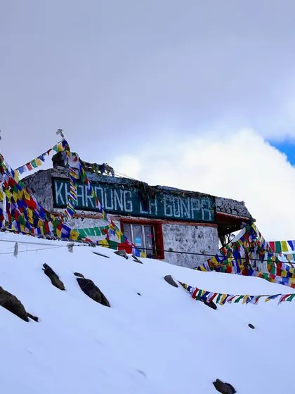 The Khardung La Gonpa, a small monastery at the top of the pass, adorned with prayer flags. These sights are part of the unique cultural experience of our fitness trips.