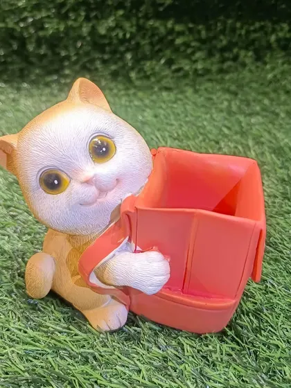 This orange cat pen holder with a red backpack is a bright and cheerful addition to any desk or workstation.