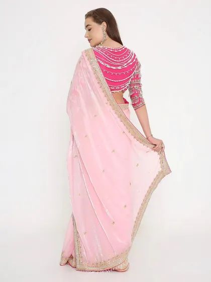 The back of this blouse is made for divas! The stunning pearl detailing on this magenta blouse adds a modern and glamorous touch to the soft pink saree.