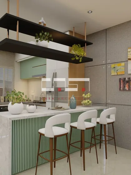 The "after" shot of a kitchen transformation, now a bright and modern space with a green and white color scheme, a marble island, and stylish bar seating.