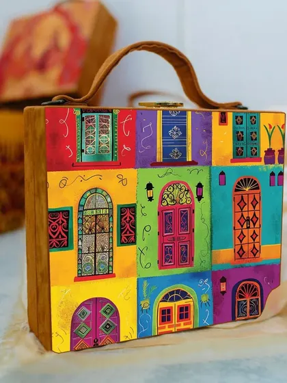 A vibrant and colorful suitcase-style bag featuring a collage of beautifully illustrated Indian doors and windows. This piece is a true conversation starter and adds a pop of color to any outfit.