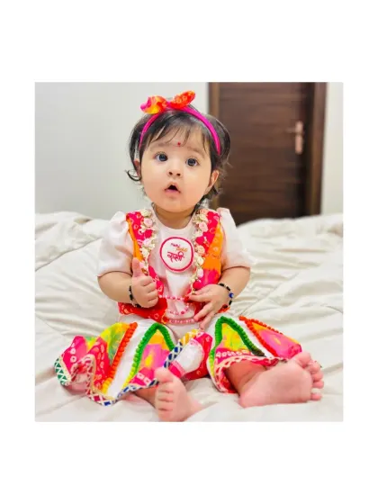 A modern take on festive wear. This little girl is wearing our colorful dhoti-style pants with a simple top and a bandhani print vest, a comfortable yet stylish choice for any festival.