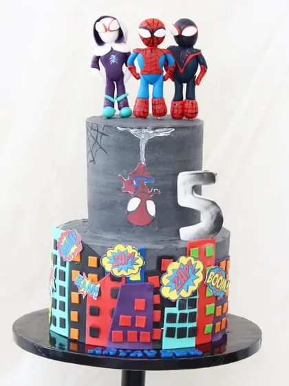 Spidey and his amazing friends are ready for action on this two-tiered cake. The design features a city skyline, comic book sound effects, and handcrafted figures of Spider-Man, Ghost-Spider, and Miles Morales.