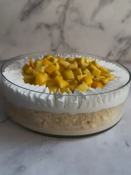 A side view of my Mango Tres Leches, showing the perfectly soaked sponge and the generous topping of whipped cream and fresh mango.