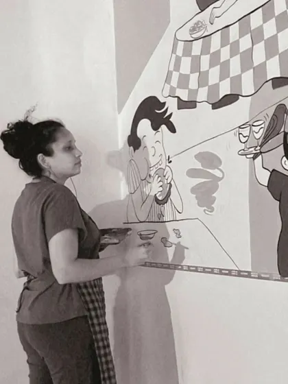 A black and white shot of me focused on the line work for the diner mural. This captures the concentration required for detailed character art.