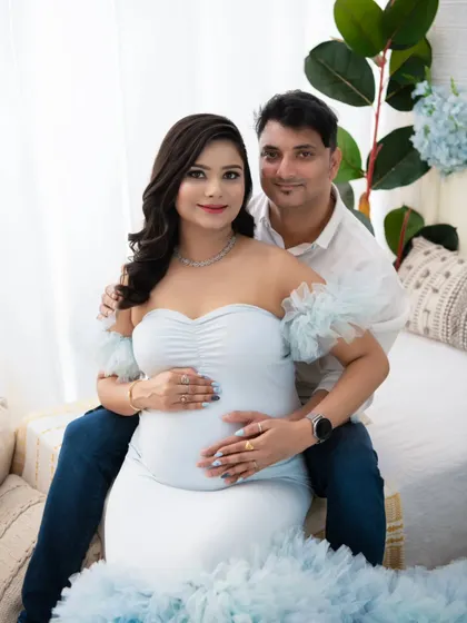 A lovely portrait of the couple seated together, looking directly at the camera. Their relaxed smiles and comfortable embrace show the easy love they share.