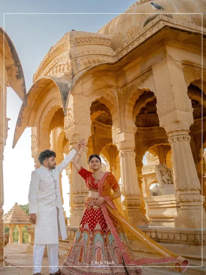 A beautiful moment of dance and celebration during a pre-wedding shoot in Rajasthan, with the groom twirling the bride in her vibrant red lehenga.