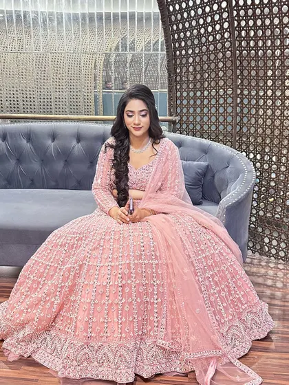 This client is all smiles, ready for her engagement in a stunning pink lehenga. The makeup is soft and pretty, with a focus on rosy tones.