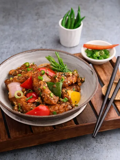 A classic chicken chilli, plated to perfection. The composition of this shot balances the vibrant colors of the bell peppers against the rich sauce, creating a dynamic and appetizing image.