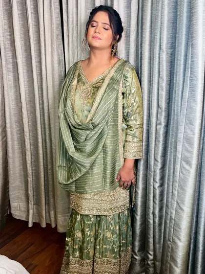 The full look, showcasing the beautiful pastel green outfit and the understated, elegant makeup.
