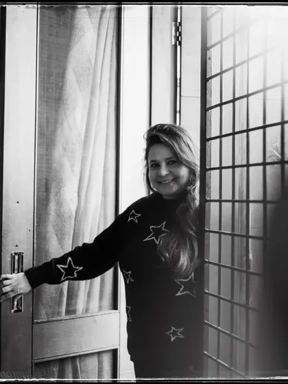 Anandita, framed by her doorway. Her warm smile makes this black and white portrait feel incredibly welcoming and bright.