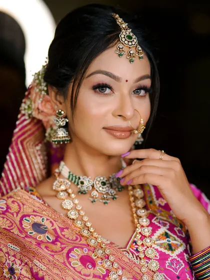 A perfect portrait of a traditional bride. The makeup is kept classic with defined eyes and a neutral lip color to let the stunning outfit and jewelry shine.