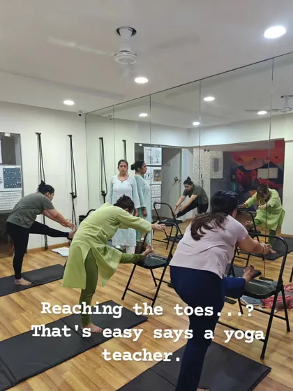 My classes are for everyone, regardless of flexibility. We often use props like chairs to make poses accessible, allowing you to get the full benefit of a stretch, like this forward bend, without compromising your form or safety.
