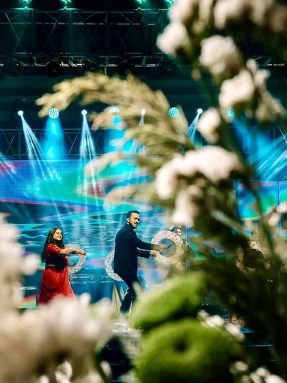 An artistic shot of the couple's Sangeet performance, framed by floral decor. This creative composition adds a unique perspective to the dance photos.