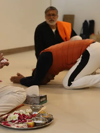 A student bows in reverence during the Diksha ceremony, an act of surrender to the teachings and the lineage. This humility is essential for receiving the profound knowledge of yoga.