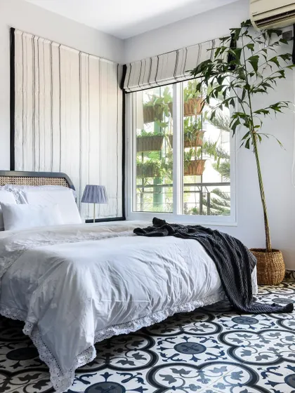 Don't be afraid of dark flooring in a bedroom. Here, bold patterned floor tiles create a stunning, high-contrast look against the white bedding and walls.