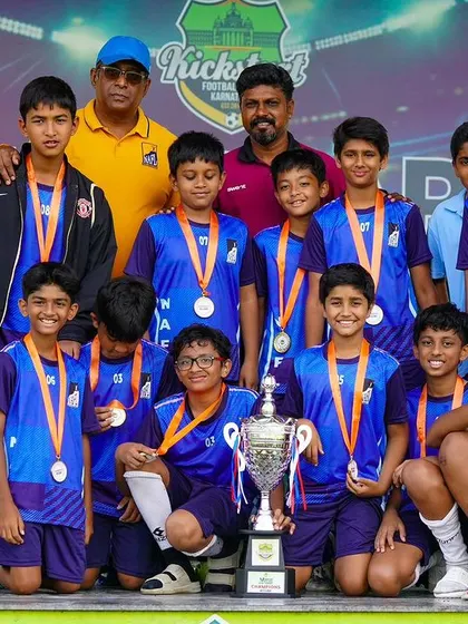 The National Academy for Learning's U-13 team celebrates their championship win, a culmination of their hard work and skill throughout the tournament.