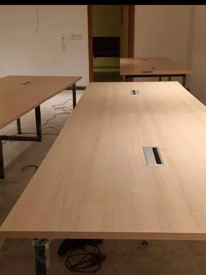Another view of our office tables during setup, highlighting the integrated cable management slots for a clean and organized workspace.