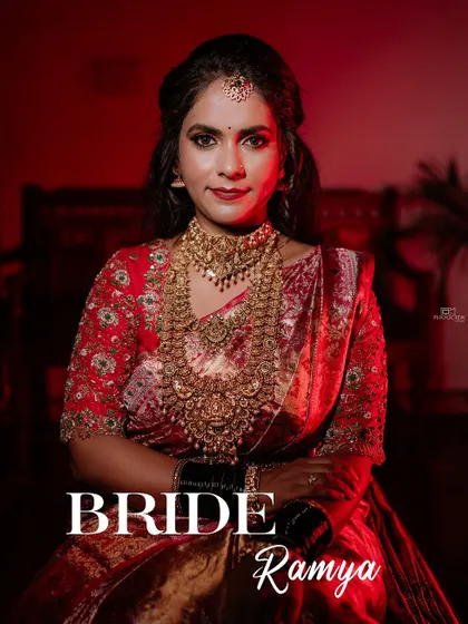 A stunning portrait of a South Indian bride in a red and gold Kanjeevaram saree, showcasing her regal look.