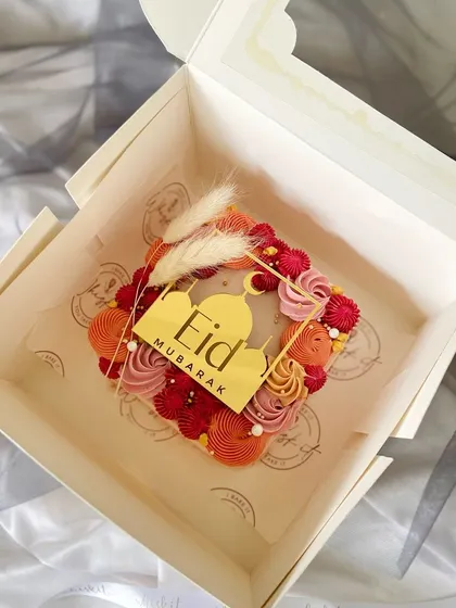 The square Eid mini cake, beautifully packaged and ready for gifting. The addition of dried pampas grass adds a touch of boho chic.