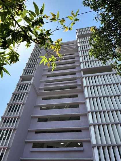 A low-angle shot of the Working Women's Housing, looking up at the facade that is designed to be both functional and beautiful, providing a comfortable and inspiring place to live.
