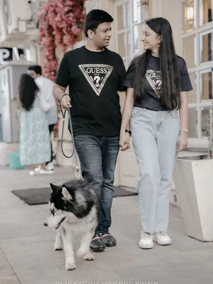 A unique pre-wedding shot featuring the couple walking their husky, perfect for pet lovers who want to include their furry friend.