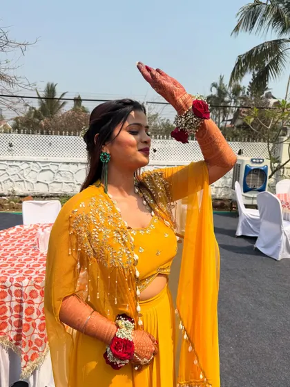 Soaking in the sun at her Haldi. The makeup is light and fresh, perfect for an outdoor daytime event.