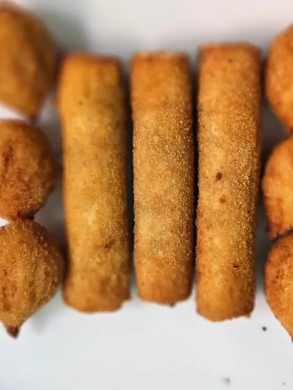 A platter of crispy fried starters, including spring rolls and vegetable cutlets, perfect for kicking off any party.