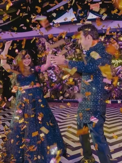 The couple celebrates under a shower of golden confetti on the dance floor of their tropical-themed party.