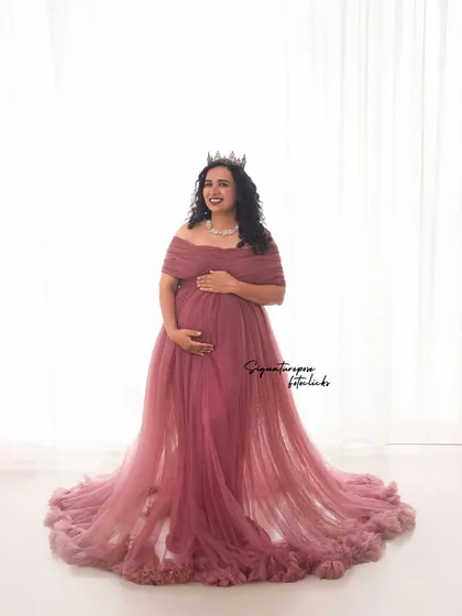 A classic high-key portrait in a beautiful mauve gown, crowned like a queen. The bright background creates a fresh, airy feel.