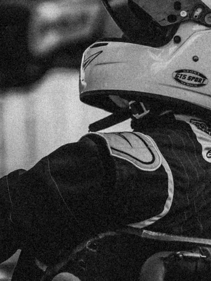 A black and white shot of a driver in his kart, capturing the timeless focus of a racer.
