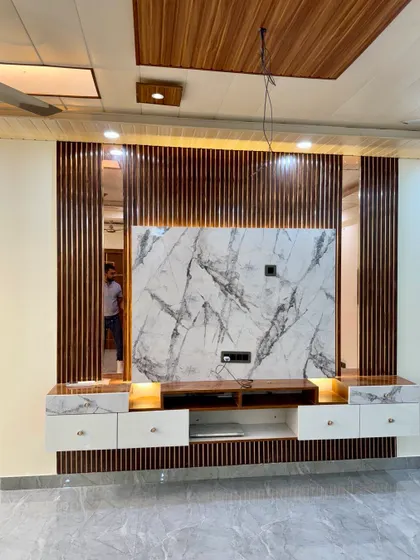 A grand TV unit with a full marble-finish back panel and wooden accents. The design includes both open shelves and closed drawers for a mix of display and storage.