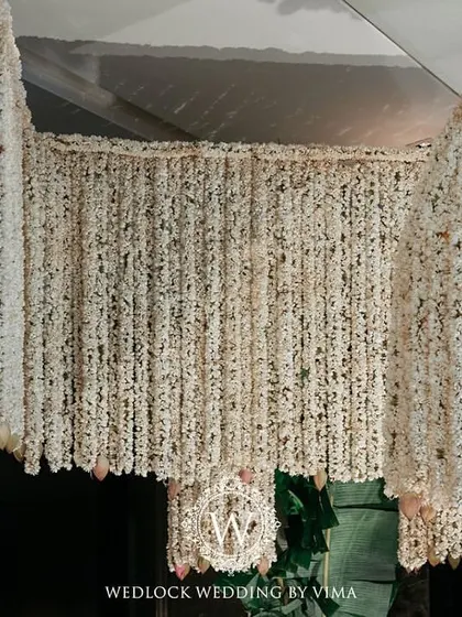 An enchanting chandelier made entirely of fragrant jasmine (mogra) and delicate pink lotuses. This was a stunning centerpiece for a traditional half-saree function, filling the air with a beautiful scent.