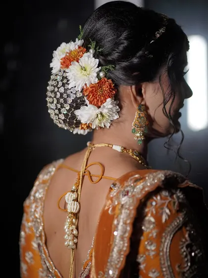 A detailed view of the floral hair bun, adorned with a traditional net accessory.