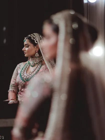 A double-reflection shot of the bride, creating an artistic and thoughtful portrait.