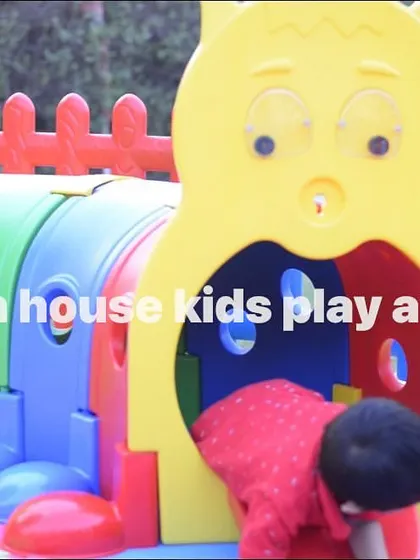 A young child exploring the colorful caterpillar play tunnel.