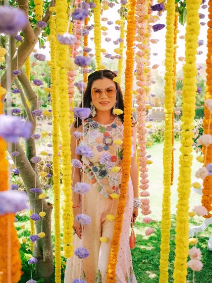 A guest poses within a curtain of colorful marigold and carnation garlands. This simple yet beautiful installation served as a perfect, interactive photo booth that was a highlight of the event.
