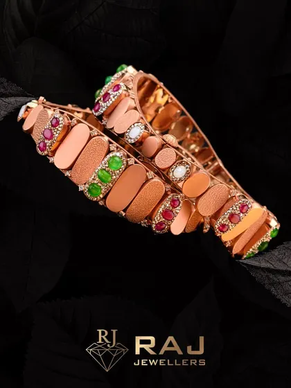 Make a statement with these exquisite rose gold kadas. The design features a modern, textured band accented with clusters of vibrant green and red stones, perfect for the contemporary bride.