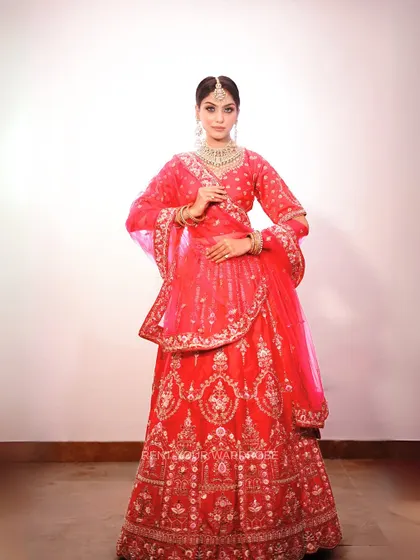 A full-length shot of the red and pink lehenga, a timeless and elegant choice.