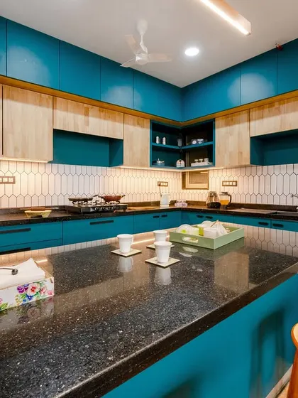 A view of the kitchen showing the full layout, including the refrigerator, ample cabinet space, and the central breakfast bar.