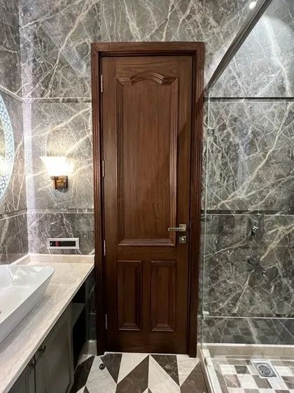 The details make the design. This bathroom at C-257 features dark grey marble walls, a solid wood door, and a beautiful checkerboard pattern on the floor, combining different textures for a rich look.