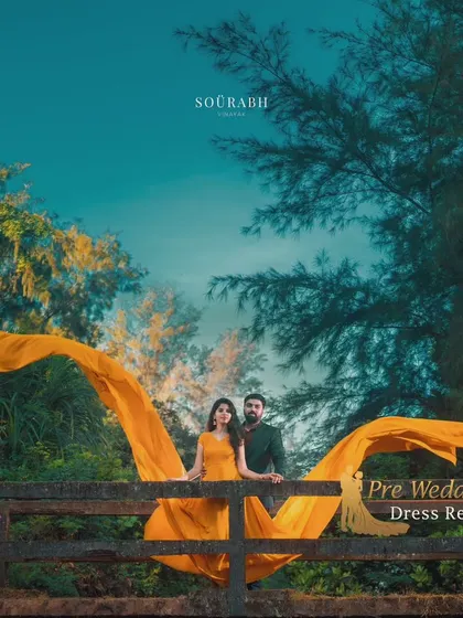 This shot showcases a yellow flying gown with the couple posing on a bridge. The way the fabric is spread out creates a stunning, wing-like effect.