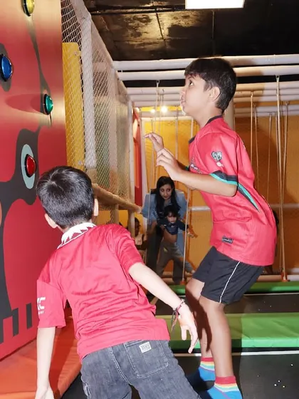 Two boys compete to see who can press the light-up buttons the fastest on the interactive wall.