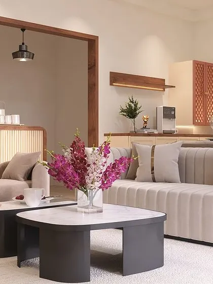 A view from the sofa, looking towards the dining and service area. The open archway, framed in dark wood, connects the spaces while creating a visual distinction between the lounge and dining zones.