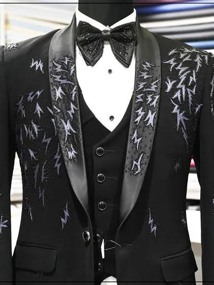 A closer view of the embroidered tuxedo, showing the detail of the threadwork on the lapels and shoulders.