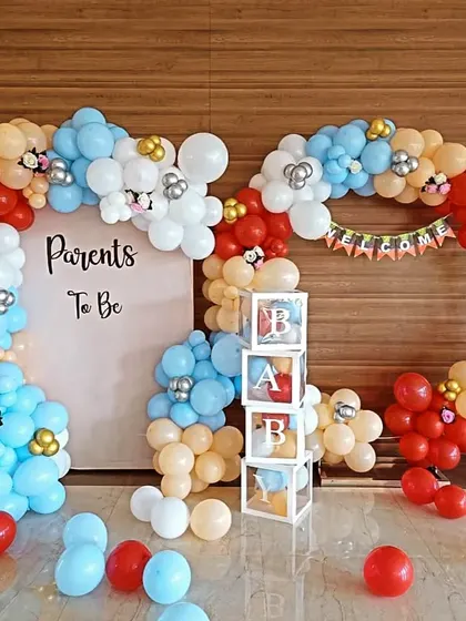 A "Parents To Be" themed baby shower with a unique balloon frame and 'BABY' blocks.