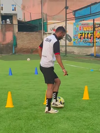 A coach shows a player the correct foot placement for a drill. This attention to detail is what helps refine a player's technique.